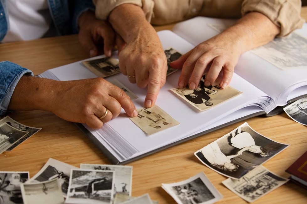 senior people looking over a family album with old photographs