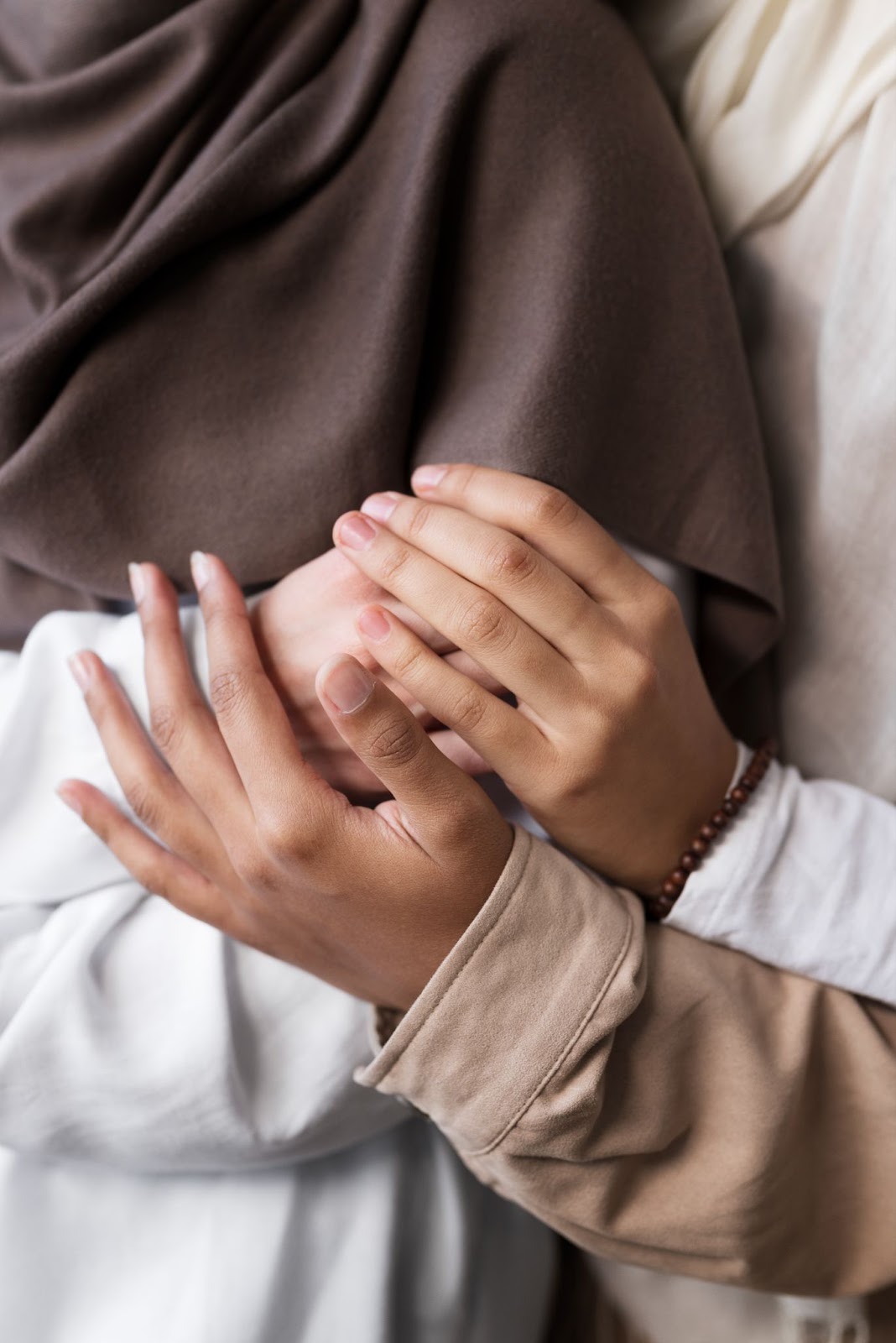 Women in hijab holding hands