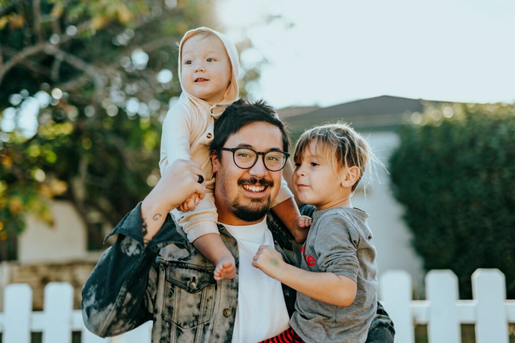 father with two children in his arms