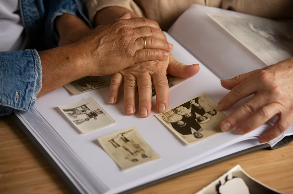 People holding hands and looking over picture album