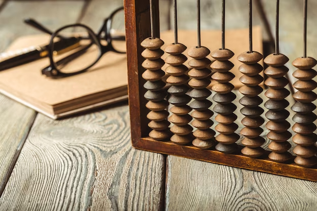 Abacus placed on a wooden table with a book and eyeglasses