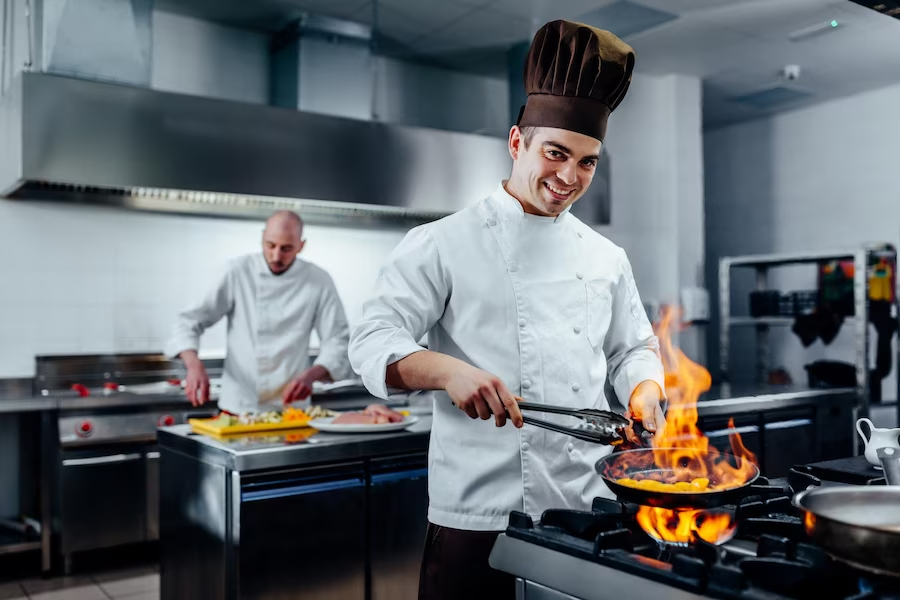 Two chefs cooking in an industrial kitchen