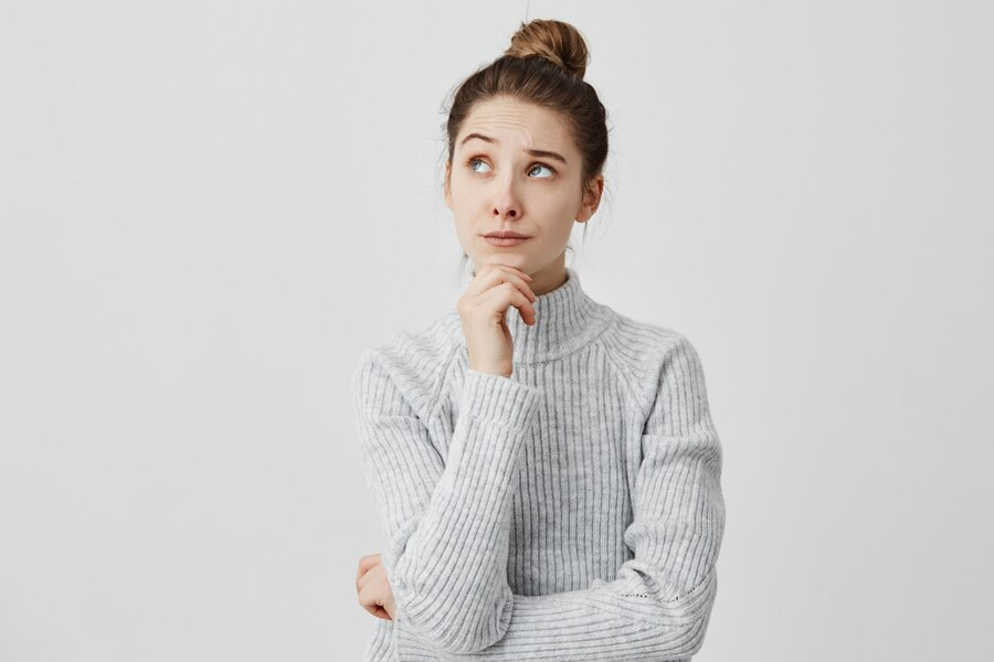 Woman tilting her head upward and sideways, holding her chin