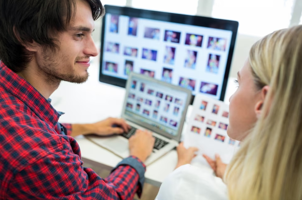 man and woman look at each other, man holds hand on the laptop