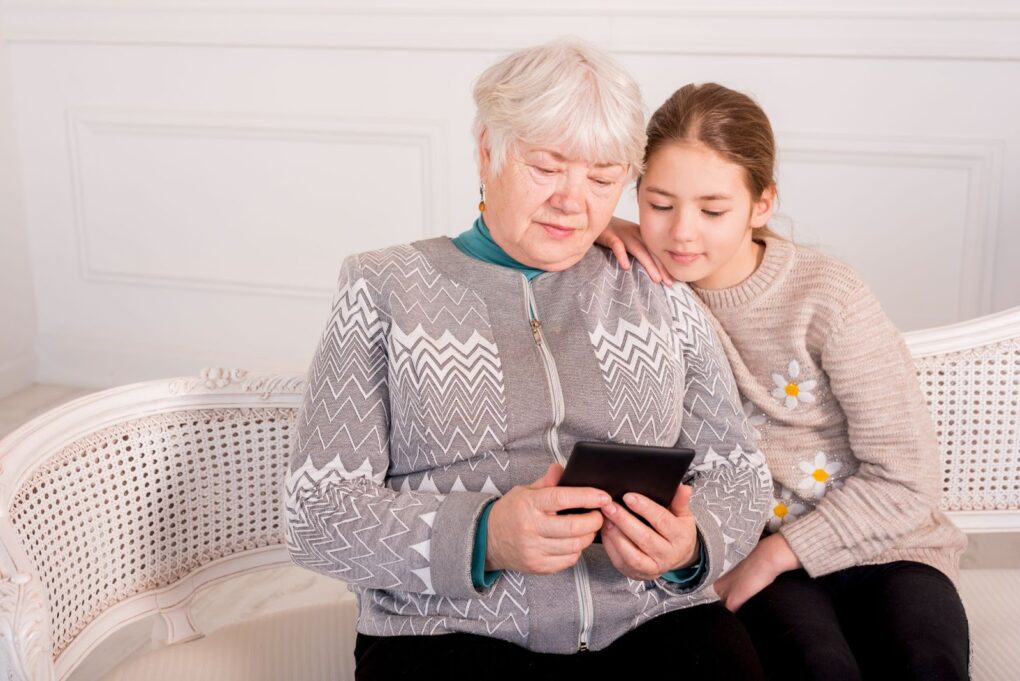 Grandma and granddaughter are looking at the phone