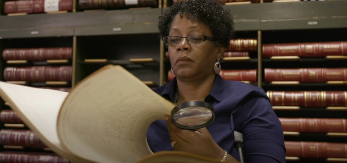 Woman reading a book with a magnifying glass